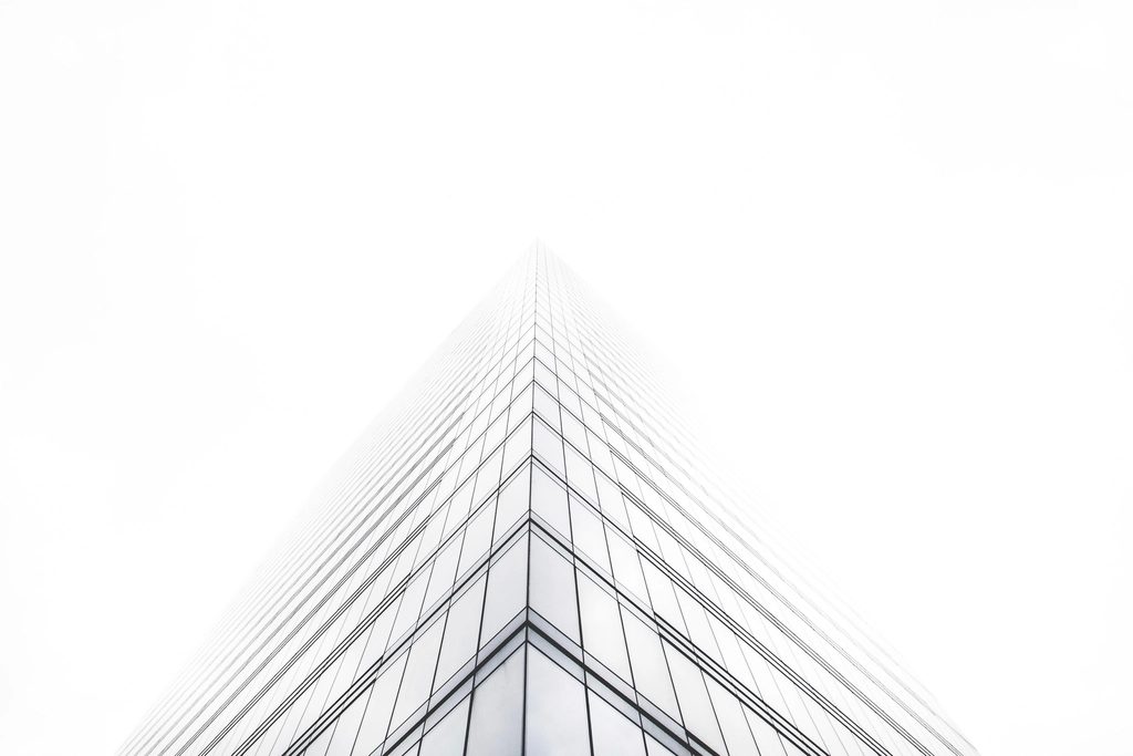 Glass office building corner disappearing into the sky.
